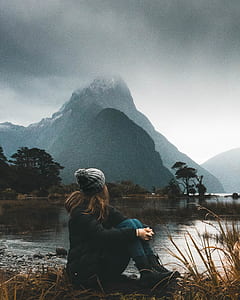 woman sitting beside body of water thumbnail