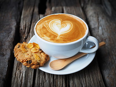 selective focus photography of poured teacup on saucer between spoon and cookie thumbnail