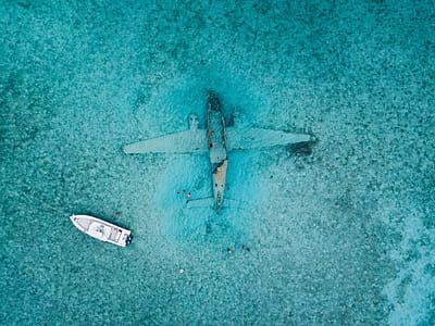 Top View Photo of Boat Near Airplane thumbnail