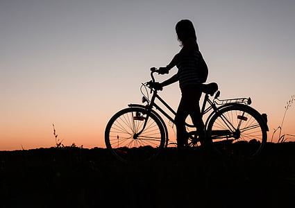 silhouette of woman holding bicycle thumbnail