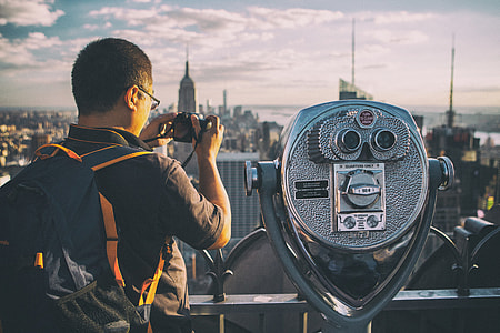 A tourist takes a picture with his camera on the Top Of The Rock observation deck at the famous Rockefeller Center, Manhattan, New York City thumbnail