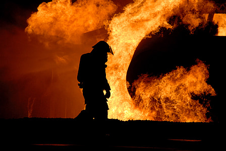 silhouette of firefighter in front of flame photo thumbnail