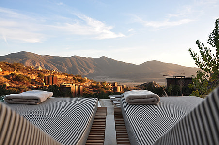 two white lounger facing to mountain during daytime thumbnail