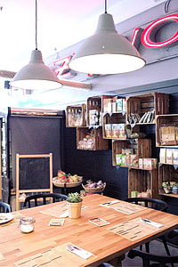 rectangular wooden table with black chairs set below a two gray pendant lamps thumbnail
