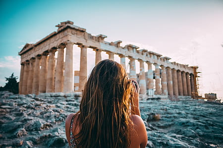 woman standing in front of ruins landmark thumbnail