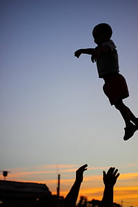 silhouette photography of child on air with a person catching him thumbnail