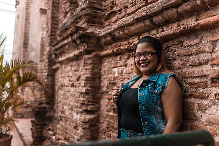 Woman Leaning on Brown Brick Wall thumbnail
