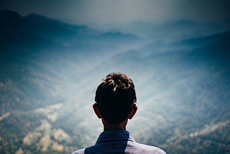 man facing towards trees and mountaints thumbnail