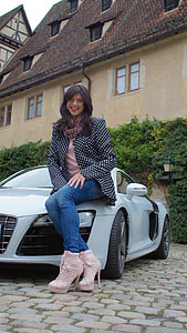 woman sitting on white Audi R8's hood near building thumbnail
