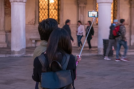 man and woman taking selfie near beige concrete building thumbnail