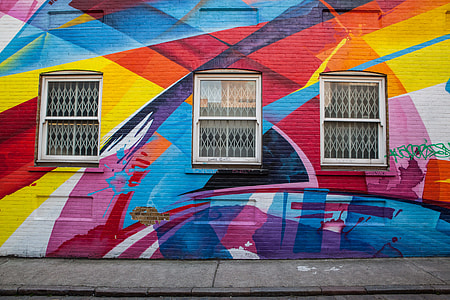 Wide angle shot of a brick building in East London that is covered in brightly coloured street art. Image captured with a Canon DSLR thumbnail