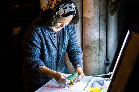 person standing at desk holding green and yellow pack thumbnail