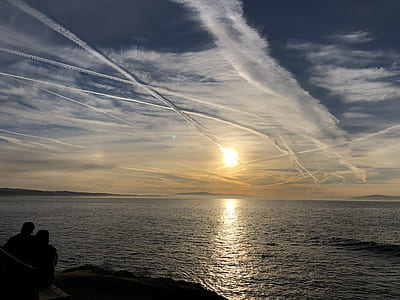 silhouette photo of man and woman beside sea thumbnail