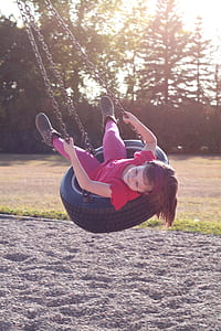 girl sitting on black swing during daytime thumbnail
