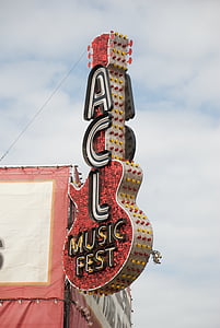 red, white, and yellow ACL Music Fest guitar signage under blue and white cloudy skies at daytime thumbnail