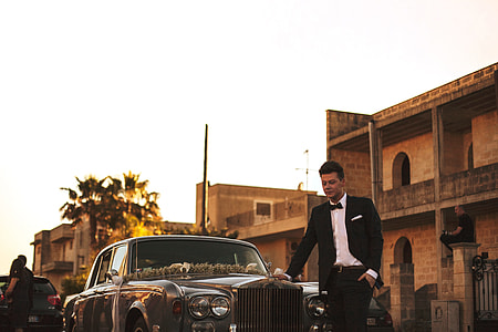 man in black coat with car thumbnail