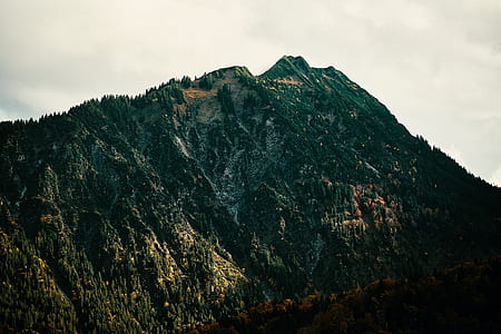 green and brown mountain under cloudy sky thumbnail