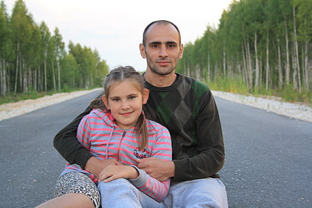 man and girl sitting in the middle of the road thumbnail