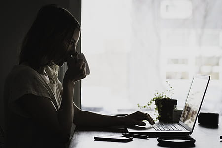 woman using laptop computer while drinking thumbnail
