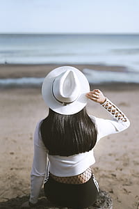 woman sitting on rock facing shoreline at daytime thumbnail
