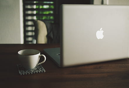 MacBook Pro on table near white ceramic teacup thumbnail