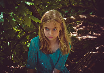 girl sitting on tree trunk during daytime thumbnail