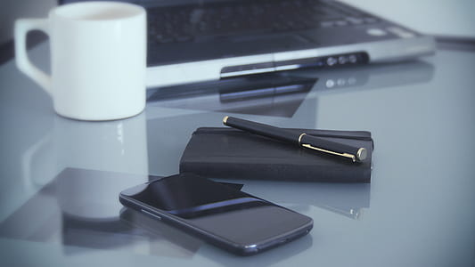 black smartphone near pen and notebook thumbnail