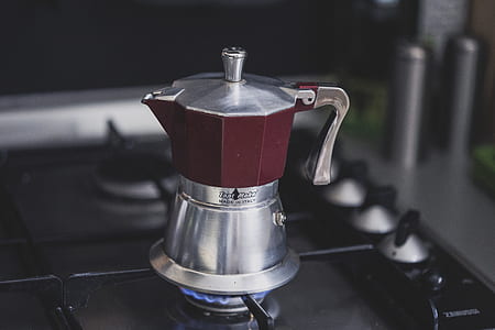 gray and red moka pot on top of turned on gas stove thumbnail