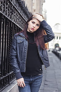 woman standing holding her head beside gate thumbnail