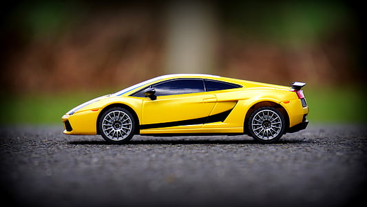 focus photo of yellow Lamborghini Gallardo scale model on gray concrete pavement thumbnail
