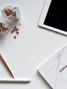 turned off white iPad near pens and glass jars thumbnail