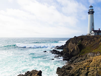 house beside lighthouse beside the ocean during day thumbnail
