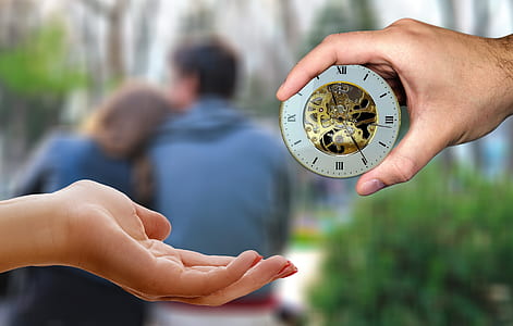 person handing gray mechanical clock on person's palm thumbnail