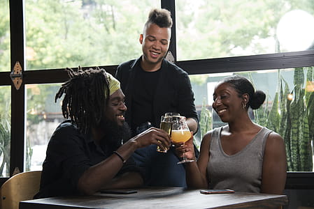 Three Persons Cheers With Clear Glasses Filled With Liquid Beverages Near Window thumbnail