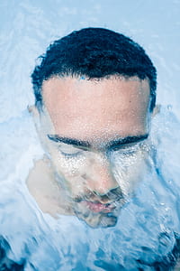 close-up photography of man bathing on body of water thumbnail