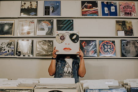 person holding vinyl sleeve standing near display thumbnail