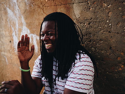 man in white and red striped T-shirt standing behind wall thumbnail