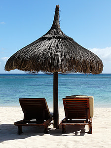 two brown sun loungers under nipa hut thumbnail