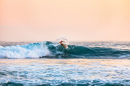 person surfing on ocean waves during daytime thumbnail