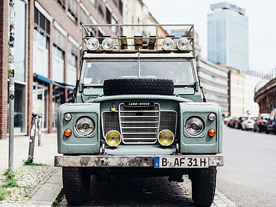 close-up photography of green Land-Rover vehicle parking near building thumbnail