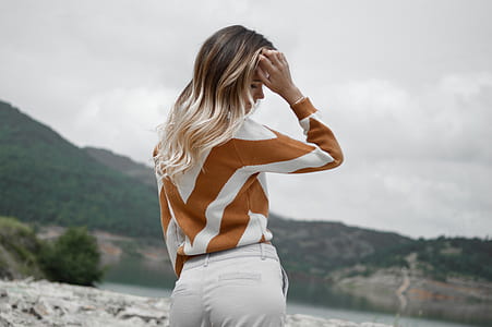 woman wearing brown and white long-sleeved top and white pants thumbnail