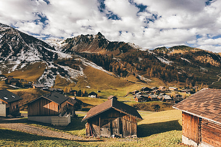 empty brown wooden houses near mountain during daytime thumbnail
