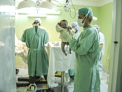 man holding baby inside room with doctor thumbnail