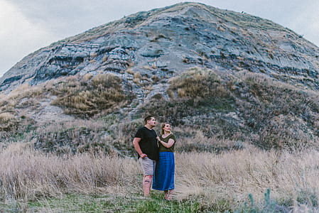 man and woman taking photo near hill thumbnail