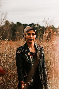woman standing on dried trees thumbnail