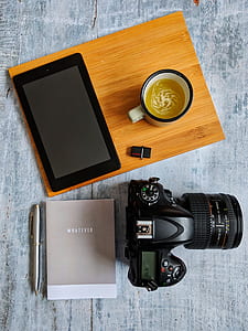DSLR camera beside mug and tablet thumbnail