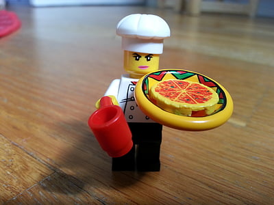chef holding pizza Lego minifig on brown surface thumbnail