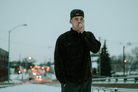man in black jacket standing on outdoors thumbnail