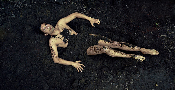 man covered in black soil thumbnail