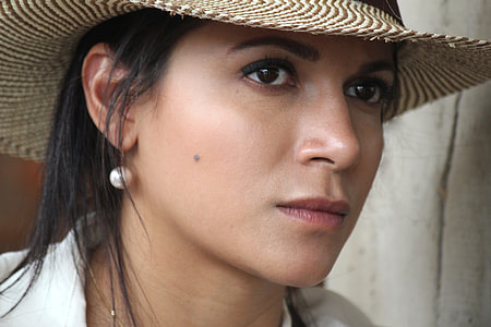 close up photo of woman wearing white shirt and brown hat thumbnail